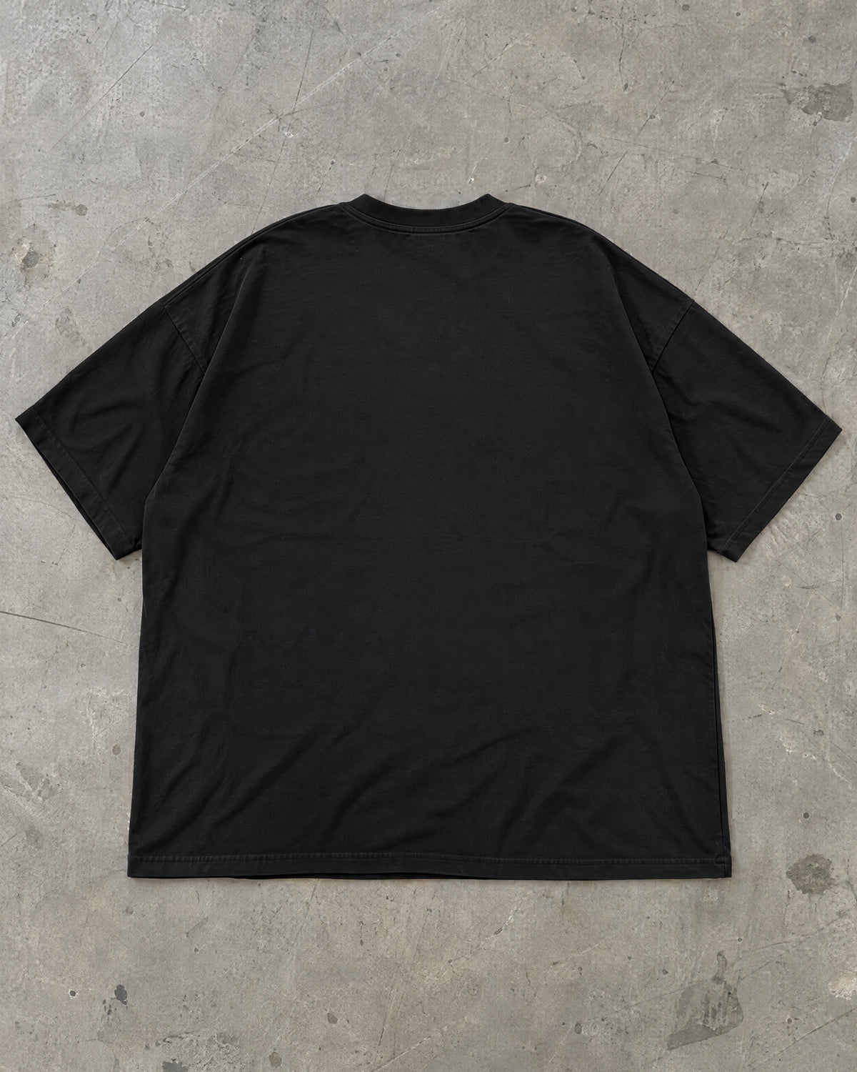 Costas lisas da camiseta oversized preta Nookie Manchete estendida no chão de concreto
