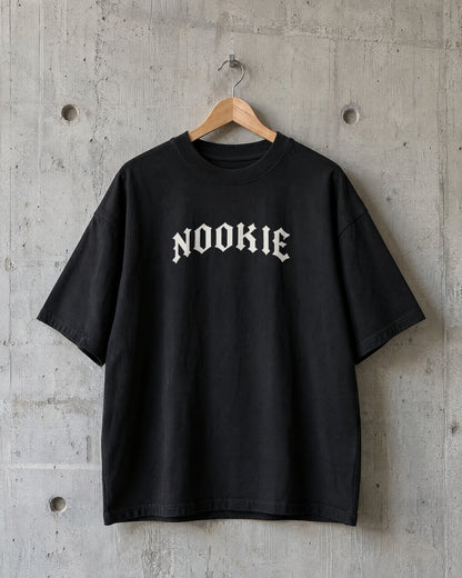 Camiseta oversized preta Nookie Manchete no cabide, de frente, com o logo NOOKIE em branco osso