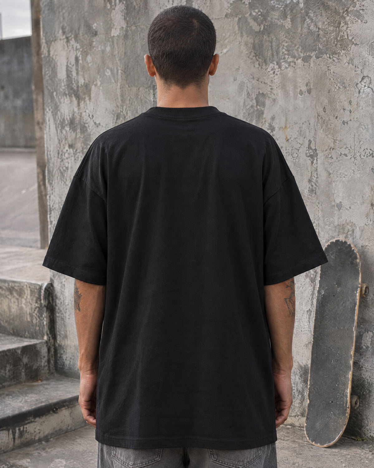 Skatista de costas vestindo a camiseta oversized tubular preta Nookie Manchete: costas lisas e caimento quadrado